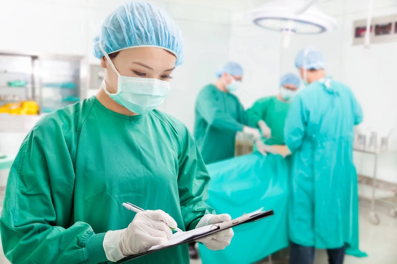 Surgeon writing notes in operating room.